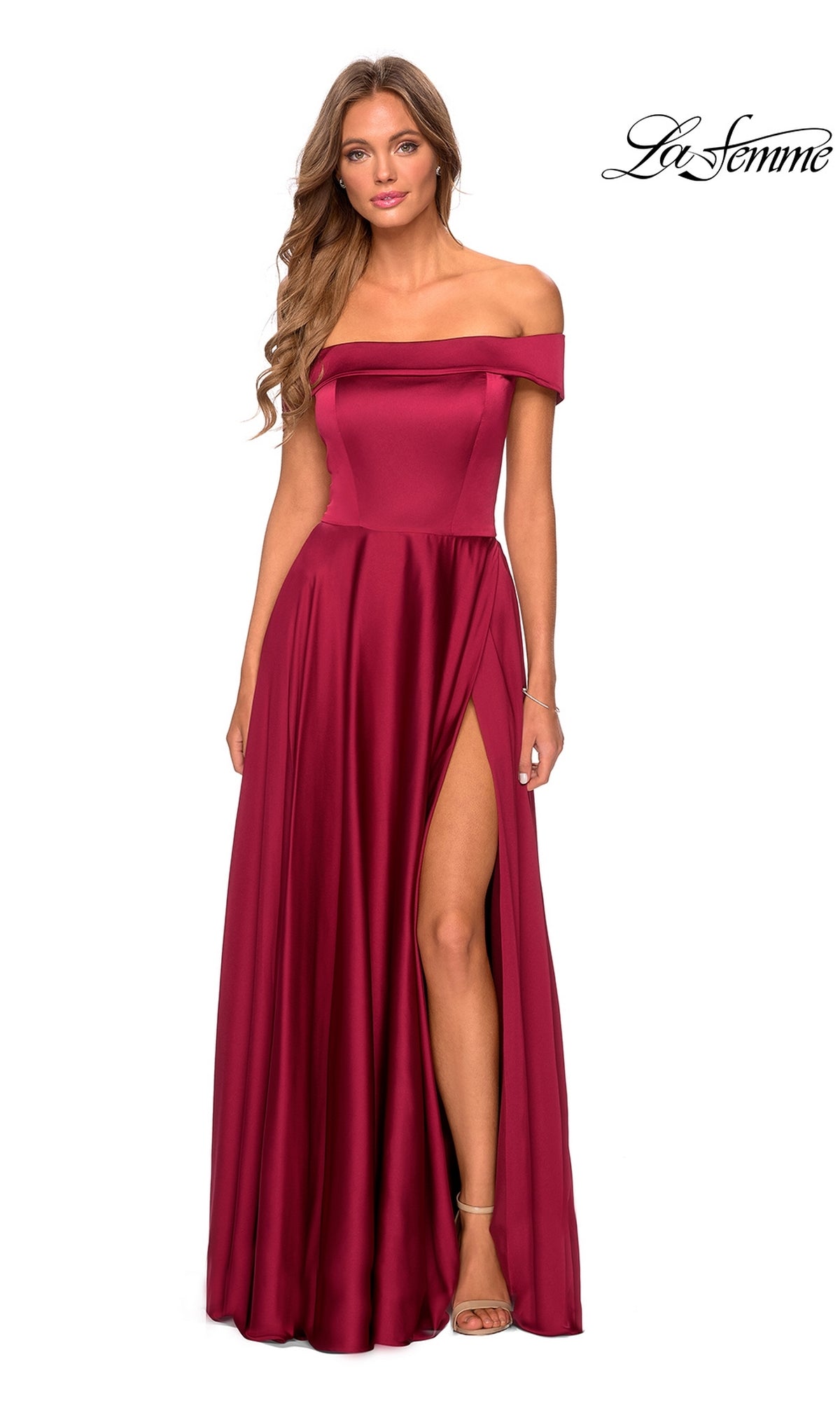 A woman models the La Femme Off-Shoulder Long A-Line Prom Dress 28978 in burgundy, featuring a floor-length skirt and thigh-high slit, standing before a white background with the La Femme logo in the top right corner.